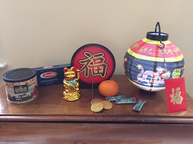 Lucky cat, lantern, rooster charm, chocolate coins, red envelope, new year symbol, peanuts, spaghetti (long noodles) tangerine, ginger chews